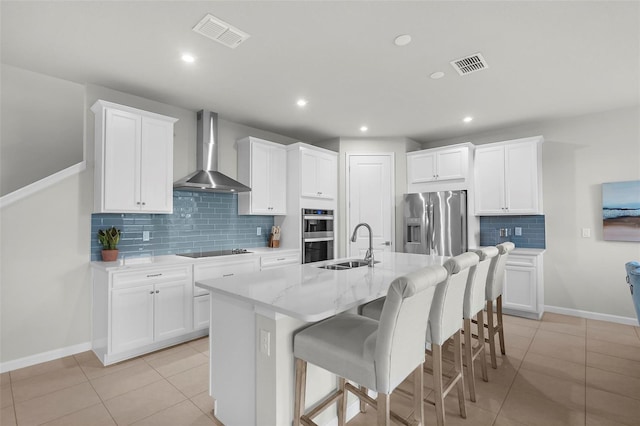 kitchen featuring wall chimney exhaust hood, visible vents, stainless steel appliances, and tasteful backsplash