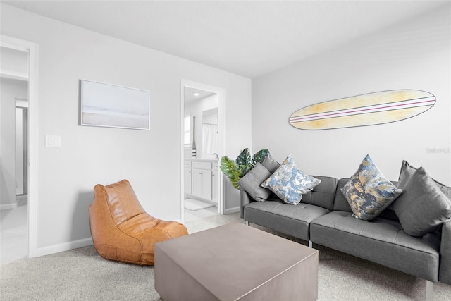 living area with light colored carpet and baseboards