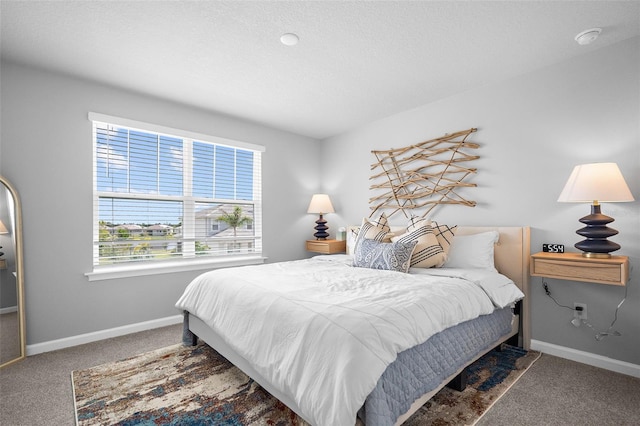 bedroom with carpet, a textured ceiling, and baseboards