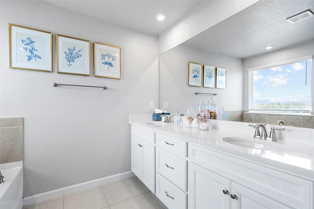 full bath with tile patterned floors, baseboards, double vanity, and a sink