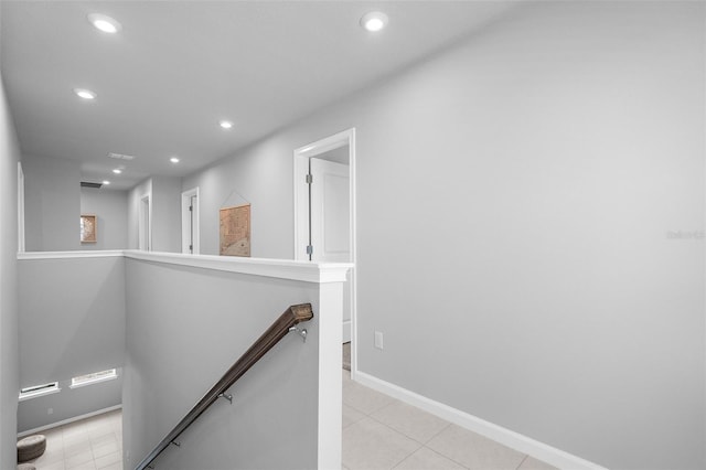 corridor with light tile patterned floors, recessed lighting, an upstairs landing, and baseboards