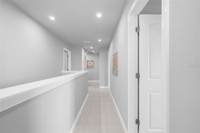 corridor with light tile patterned floors, recessed lighting, and baseboards