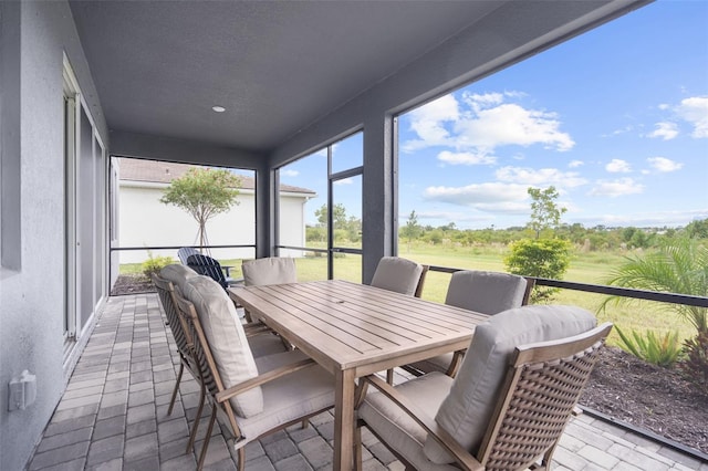 sunroom featuring outdoor dining area