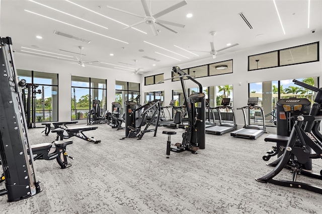 exercise room featuring recessed lighting, a ceiling fan, visible vents, and a towering ceiling