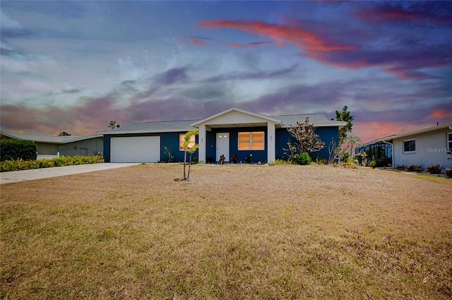 ranch-style home with a garage, stucco siding, a lawn, and driveway