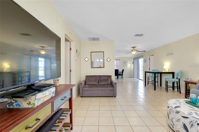 living room featuring visible vents, a ceiling fan, light tile patterned flooring, and a wealth of natural light
