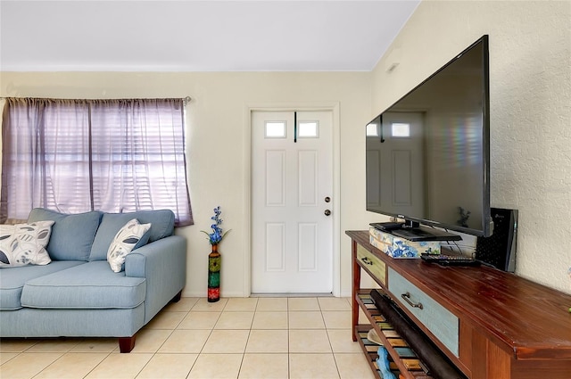 foyer entrance featuring a textured wall and light tile patterned flooring