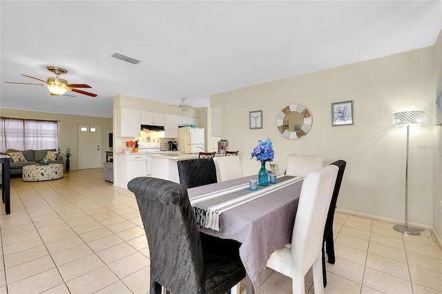 dining area with visible vents, a ceiling fan, baseboards, and light tile patterned floors
