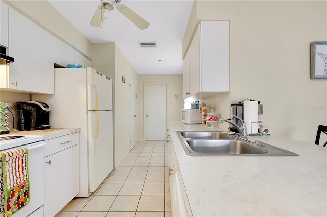 kitchen with a sink, white appliances, light countertops, white cabinetry, and visible vents