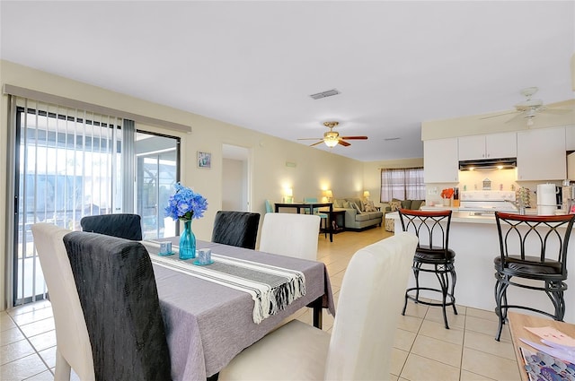 dining space with ceiling fan, visible vents, and light tile patterned floors