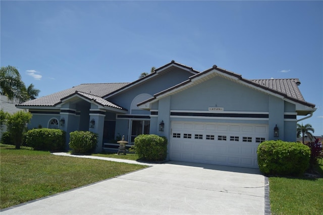 ranch-style home with a tile roof, a front lawn, a garage, concrete driveway, and stucco siding