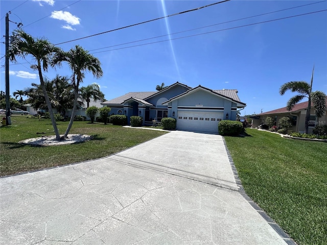 ranch-style house featuring a front lawn, an attached garage, and concrete driveway