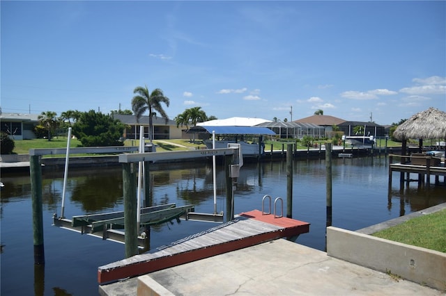 view of dock with boat lift, a residential view, and a water view