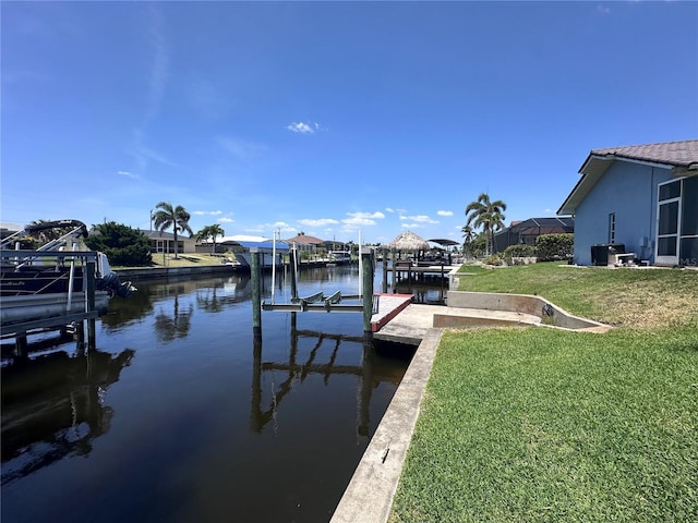 view of dock featuring a yard, a water view, and boat lift