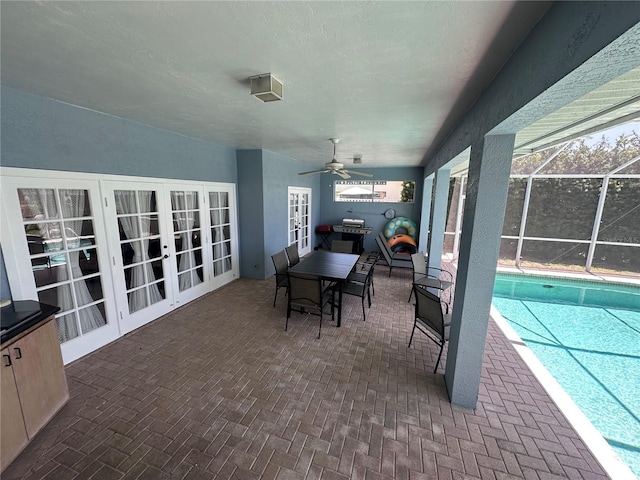 outdoor pool featuring a patio, french doors, glass enclosure, and a ceiling fan