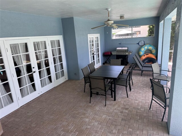 view of patio / terrace featuring outdoor dining space, grilling area, a ceiling fan, and french doors