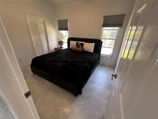 bedroom featuring baseboards and a closet