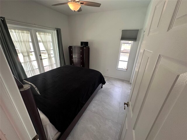 bedroom featuring ceiling fan, baseboards, and multiple windows
