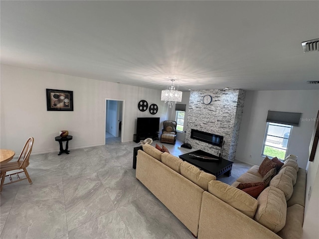 living area with visible vents, baseboards, a chandelier, and a fireplace
