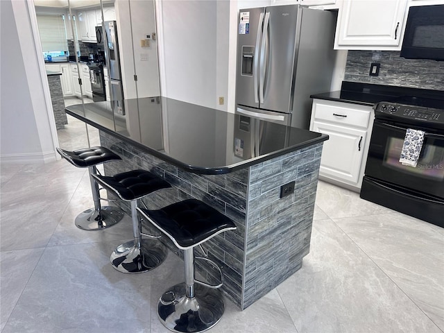 kitchen with tasteful backsplash, black appliances, a breakfast bar, dark countertops, and white cabinets