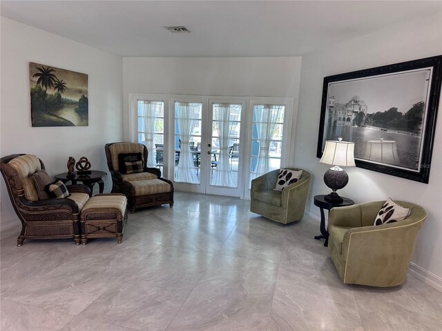 sitting room featuring baseboards, visible vents, and french doors