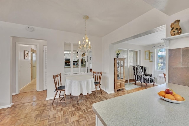 dining area featuring an inviting chandelier and baseboards