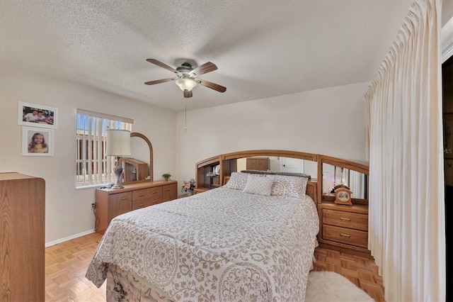 bedroom with baseboards, a ceiling fan, and a textured ceiling