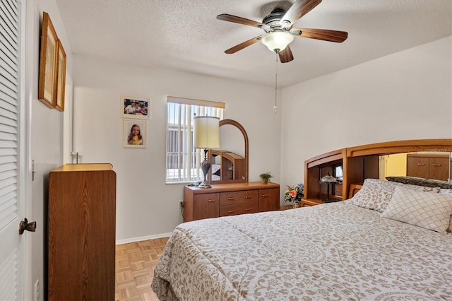 bedroom with baseboards, a ceiling fan, and a textured ceiling