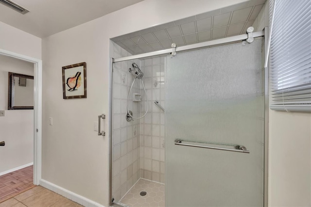 bathroom featuring baseboards, a shower stall, and visible vents