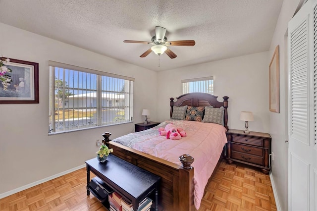 bedroom featuring a textured ceiling, baseboards, and a ceiling fan