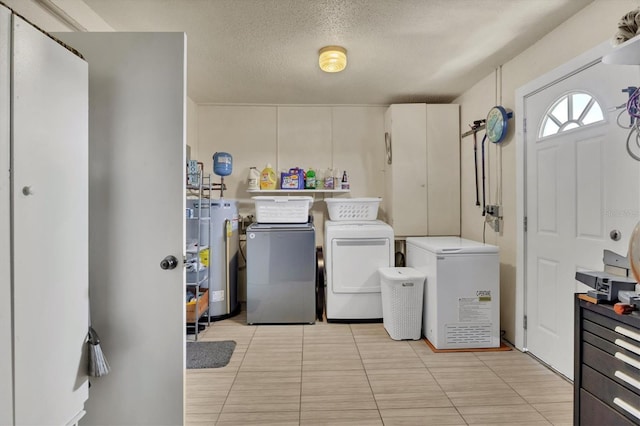 washroom with laundry area, light tile patterned flooring, a textured ceiling, gas water heater, and separate washer and dryer