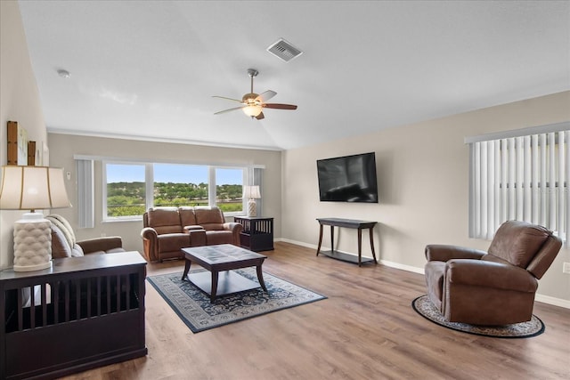 living room featuring a ceiling fan, baseboards, wood finished floors, vaulted ceiling, and visible vents