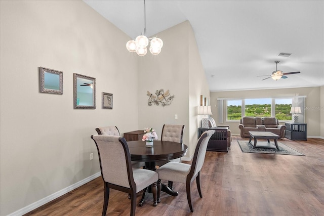 dining space with visible vents, baseboards, wood finished floors, and high vaulted ceiling