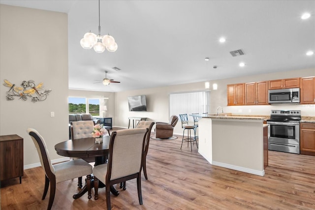 dining area with visible vents, baseboards, recessed lighting, light wood-style flooring, and ceiling fan with notable chandelier