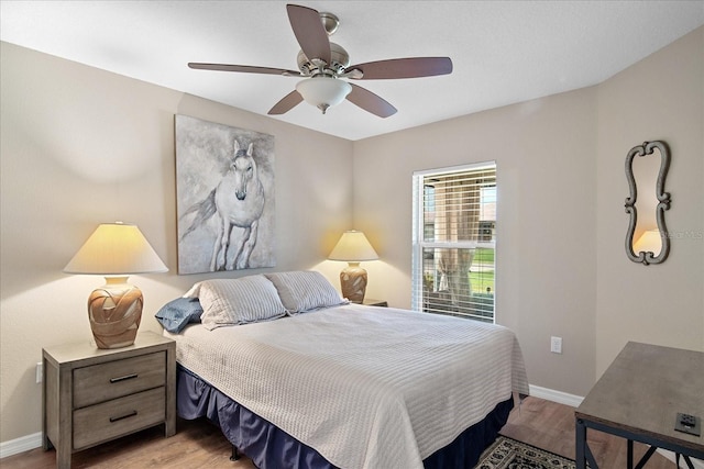 bedroom featuring baseboards, a ceiling fan, and light wood finished floors