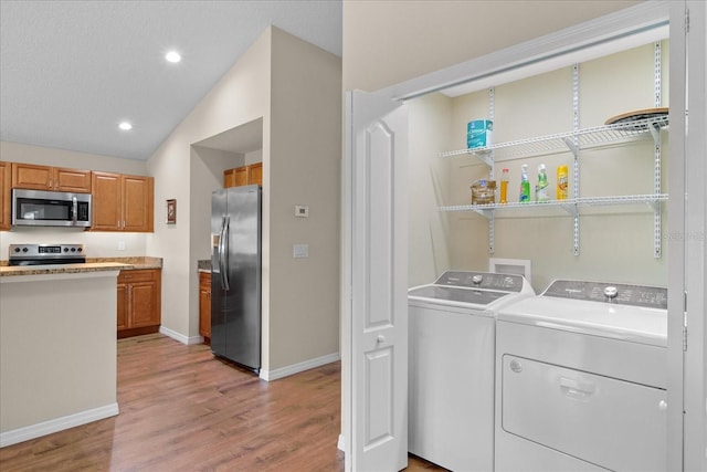 washroom featuring laundry area, baseboards, recessed lighting, light wood-type flooring, and separate washer and dryer
