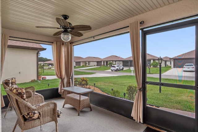 sunroom / solarium featuring a residential view and ceiling fan