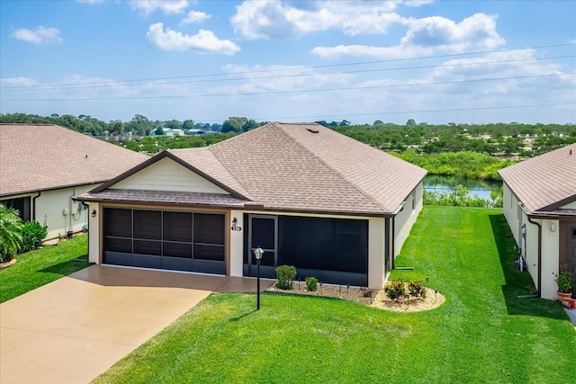 single story home featuring a shingled roof, an attached garage, driveway, and a front yard