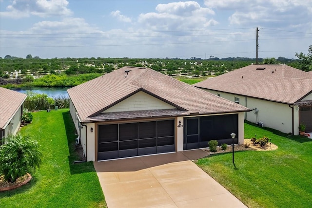 ranch-style home with roof with shingles, a sunroom, a garage, and a front yard
