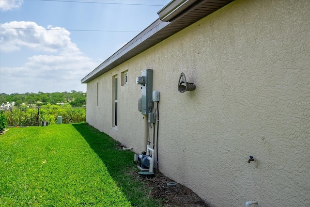 view of side of home featuring a lawn and stucco siding