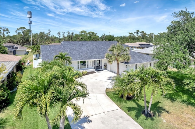ranch-style home with driveway, a garage, stucco siding, and roof with shingles