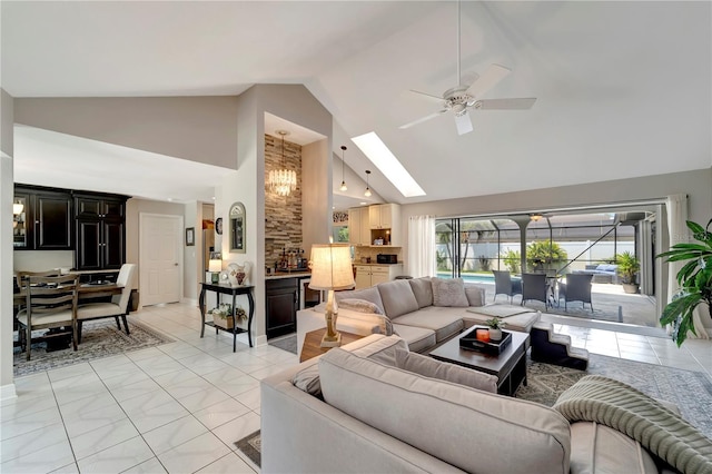 living room with a ceiling fan, high vaulted ceiling, baseboards, and a skylight