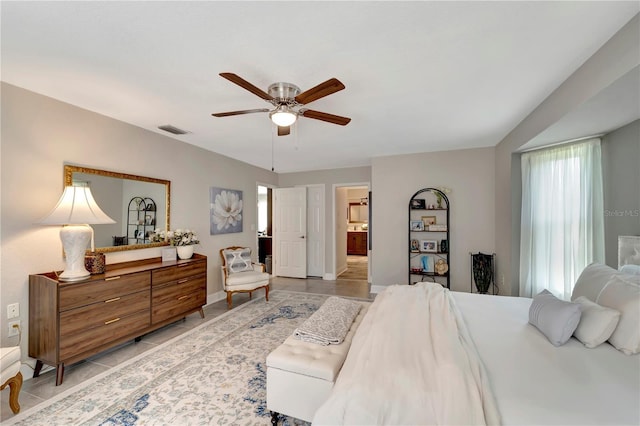 bedroom with light tile patterned floors, ceiling fan, visible vents, baseboards, and ensuite bathroom