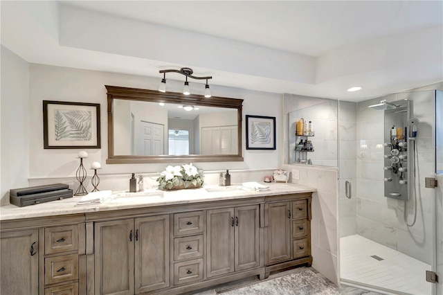full bathroom with a shower stall, double vanity, and a sink