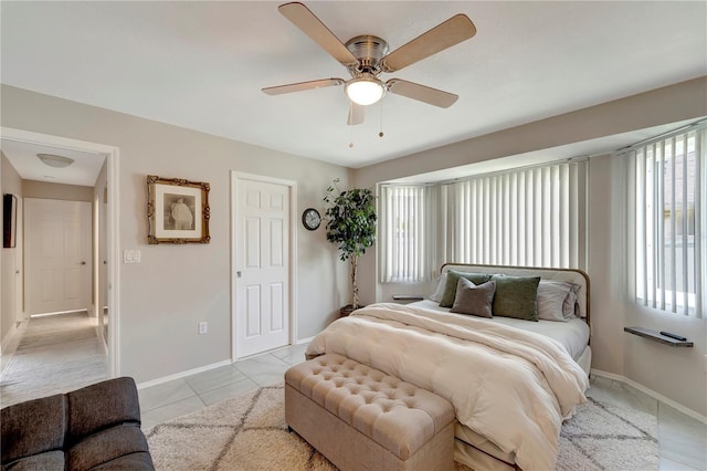bedroom with baseboards, light tile patterned floors, and multiple windows