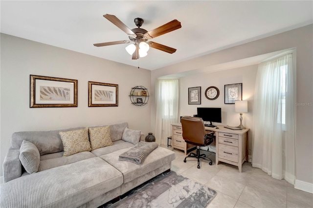 office area with ceiling fan and baseboards