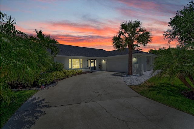 view of front facade with driveway, a garage, and stucco siding
