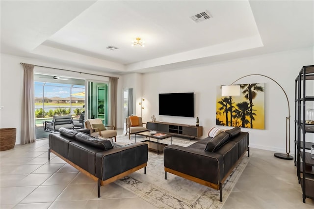 living room featuring a raised ceiling and visible vents