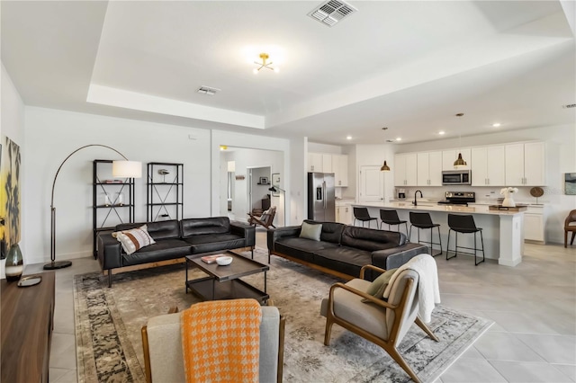 living area featuring a tray ceiling, recessed lighting, light tile patterned flooring, and visible vents