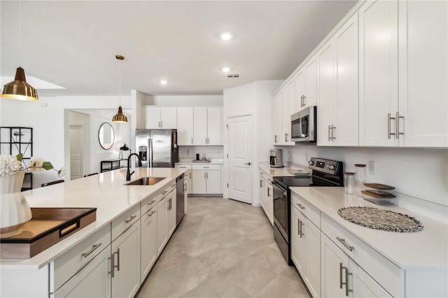 kitchen with pendant lighting, light countertops, white cabinetry, a sink, and stainless steel appliances